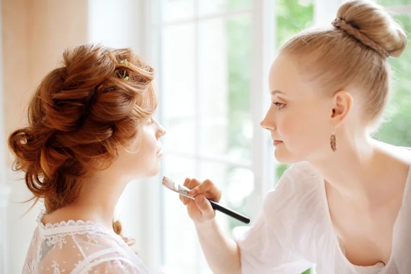 Stylist maakt make-up bruid op de huwelijksdag — Stockfoto