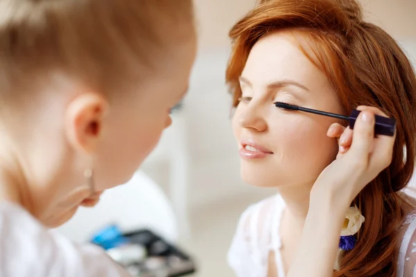 Kadeřnice dělá make-up nevěsty svatební den — Stock fotografie