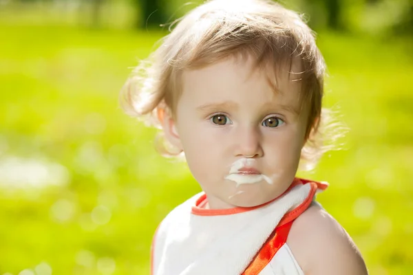 Mère nourrit bébé à l'extérieur dans l'herbe — Photo