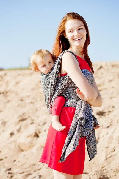 Mulher de beleza com um bebê em uma funda. Mãe e bebé. Mãe e ch — Fotografia de Stock