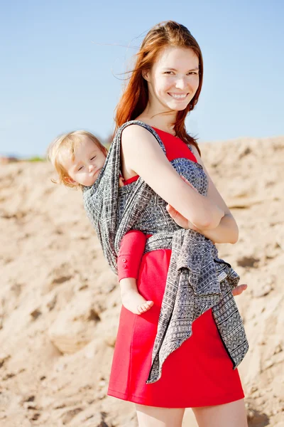 スリングで赤ちゃんを持つ美しい女性。ママと赤ちゃん。母と — ストック写真