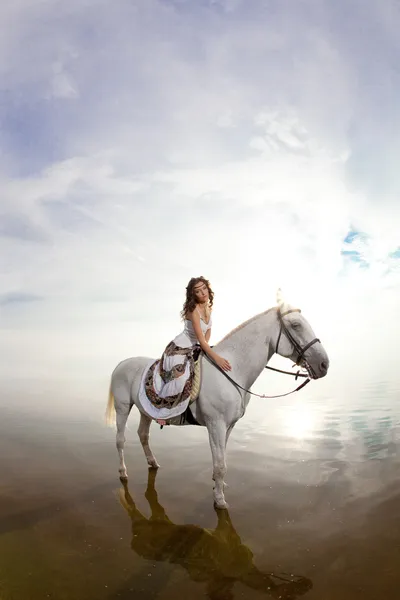 Uma jovem a cavalo. Cavaleiro, mulher montando cavalo em b — Fotografia de Stock