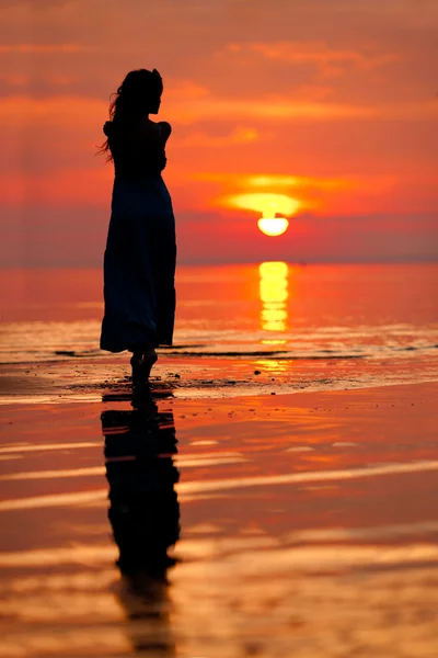 Ευτυχισμένη γυναίκα απολαμβάνοντας το ηλιοβασίλεμα στη θάλασσα. silhouetted έναντι του Σανς — Φωτογραφία Αρχείου