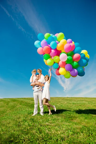 Familia feliz sosteniendo globos de colores. Mamá, Ded y dos Daughte — Foto de Stock