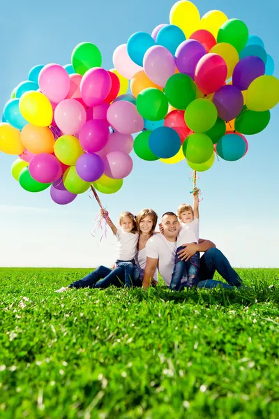 Glad familj anläggning färgglada ballonger. mamma, ded och två daughte — Stockfoto