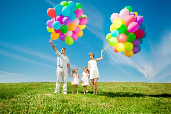 Famille heureuse tenant des ballons colorés en plein air. Maman, ded et deux — Photo