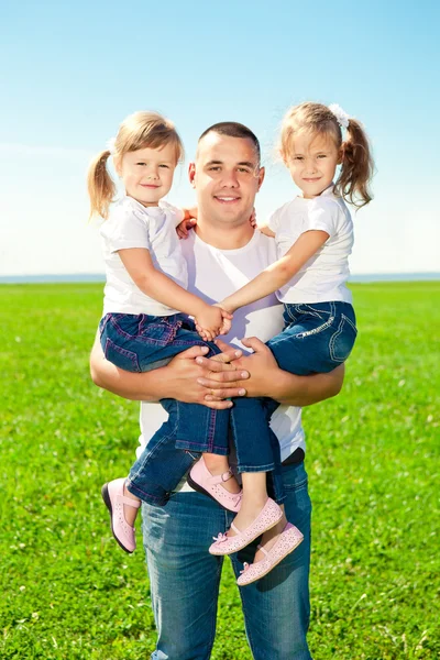 Família feliz juntos no parque ao ar livre no dia ensolarado. O pai e dois. — Fotografia de Stock