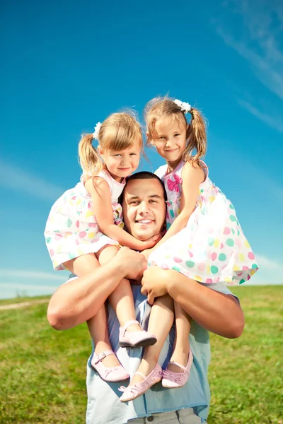 Família feliz juntos no parque ao ar livre no dia ensolarado. O pai e dois. — Fotografia de Stock