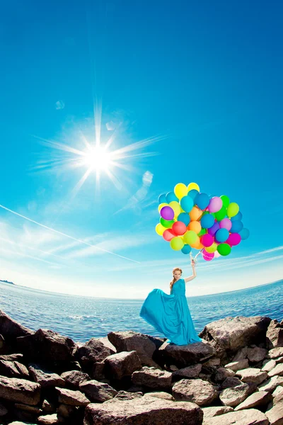 Luxusmode Frau mit Luftballons in der Hand am Strand gegen — Stockfoto