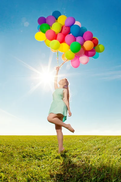 Mujer de moda de lujo con globos en la mano en el campo contra — Foto de Stock