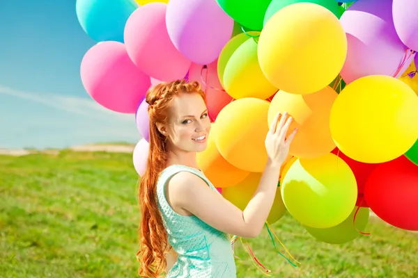 Mujer de moda de lujo con globos en la mano en el campo contra —  Fotos de Stock