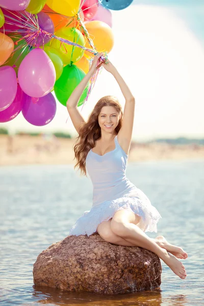 Hermosa mujer joven y elegante con globo de arco iris multicolor — Foto de Stock