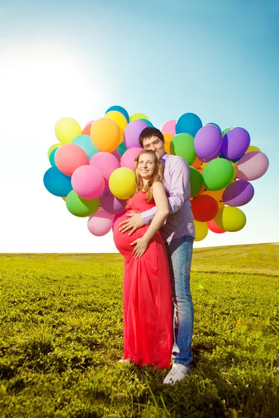 Genç sağlıklı güzellik hamile kadın kocasının ve balon ile — Stok fotoğraf