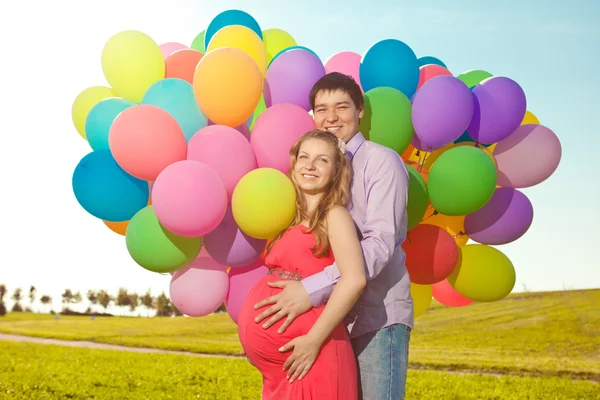 年轻健康的美丽孕妇与她的丈夫和气球 — 图库照片