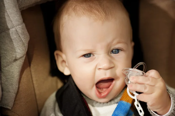 Schönes kleines lächelndes Baby im Kinderwagen auf der Straße — Stockfoto