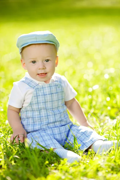 Cute little baby in the park on the grass. Sweet baby outdoors. — Φωτογραφία Αρχείου