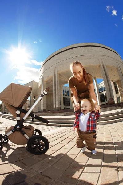 Trendy modern mother on a city street with a pram. Young mother — Stock Photo, Image