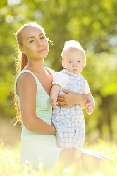 Cute little baby in summer park with mother on the grass. Swee — Stock Photo, Image