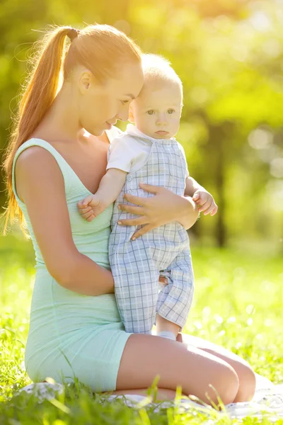 Cute little baby in the park with mother on the grass. Sweet bab — Stock Photo, Image