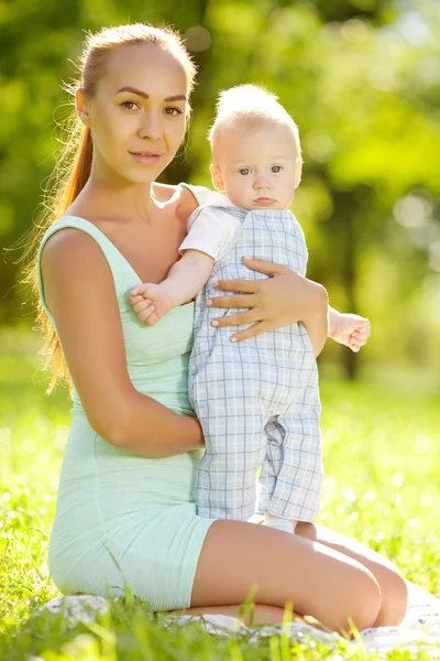 Cute little baby in the park with mother on the grass. Sweet bab — Stock Photo, Image