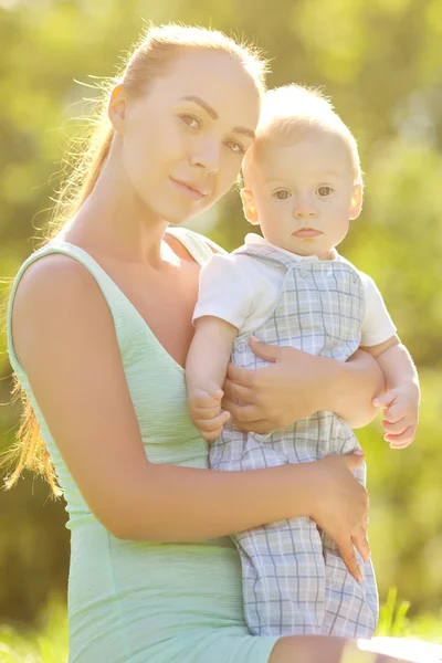 Cute little baby in the park with mother on the grass. Sweet bab — Stock Photo, Image