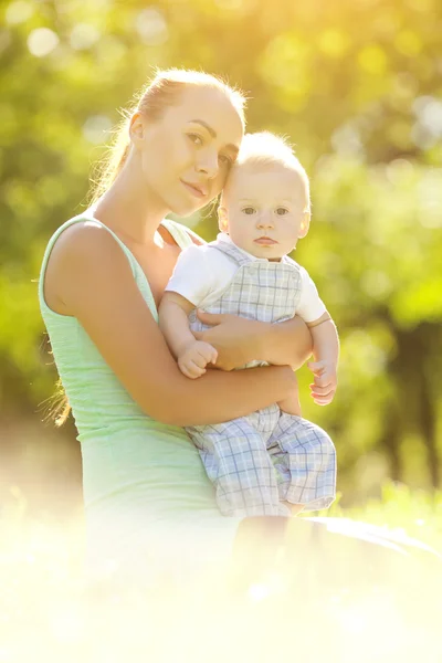 Cute little baby in the park with mother on the grass. Sweet bab — Stock Photo, Image