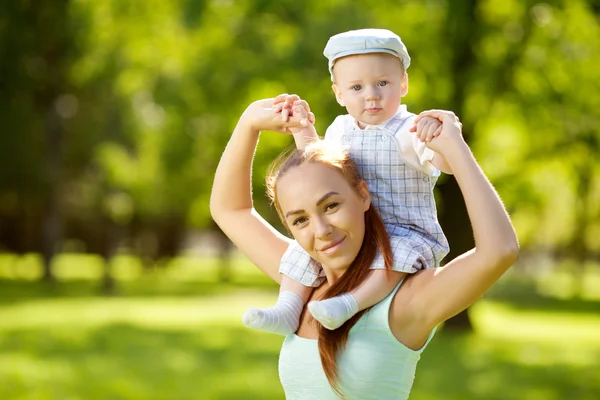 Cute little baby in the park with mother on the grass. Sweet bab — Stock Photo, Image