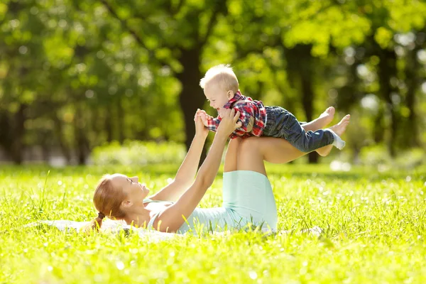 Lindo bebé en el parque con madre en la hierba. Dulce bab —  Fotos de Stock