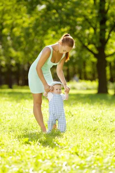 Piccolo bambino carino nel parco con la madre sull'erba. Dolce bab — Foto Stock