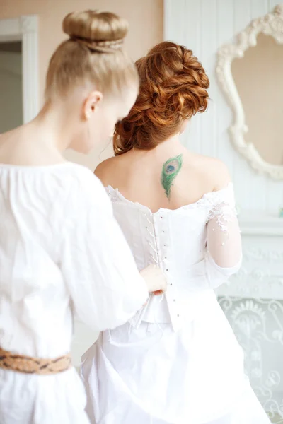 Όμορφη νύφη φοράει φόρεμα από στυλίστα Φωτογραφία Αρχείου