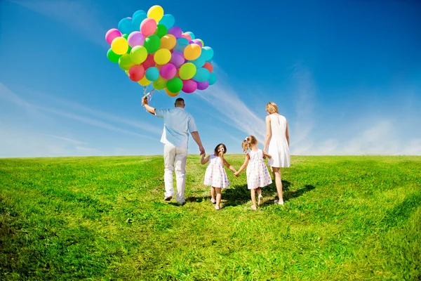Família feliz segurando balões coloridos ao ar livre. Mãe, ded e dois Fotos De Bancos De Imagens