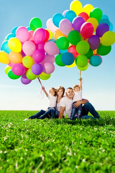 Щаслива сім'я тримає різнокольорові кульки. Мама, дед і дві доньки Стокове Фото
