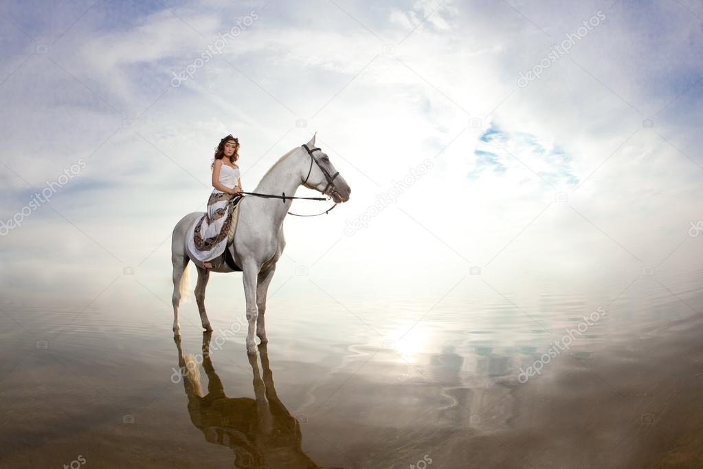 Young woman on a horse. Horseback rider, woman riding horse on b