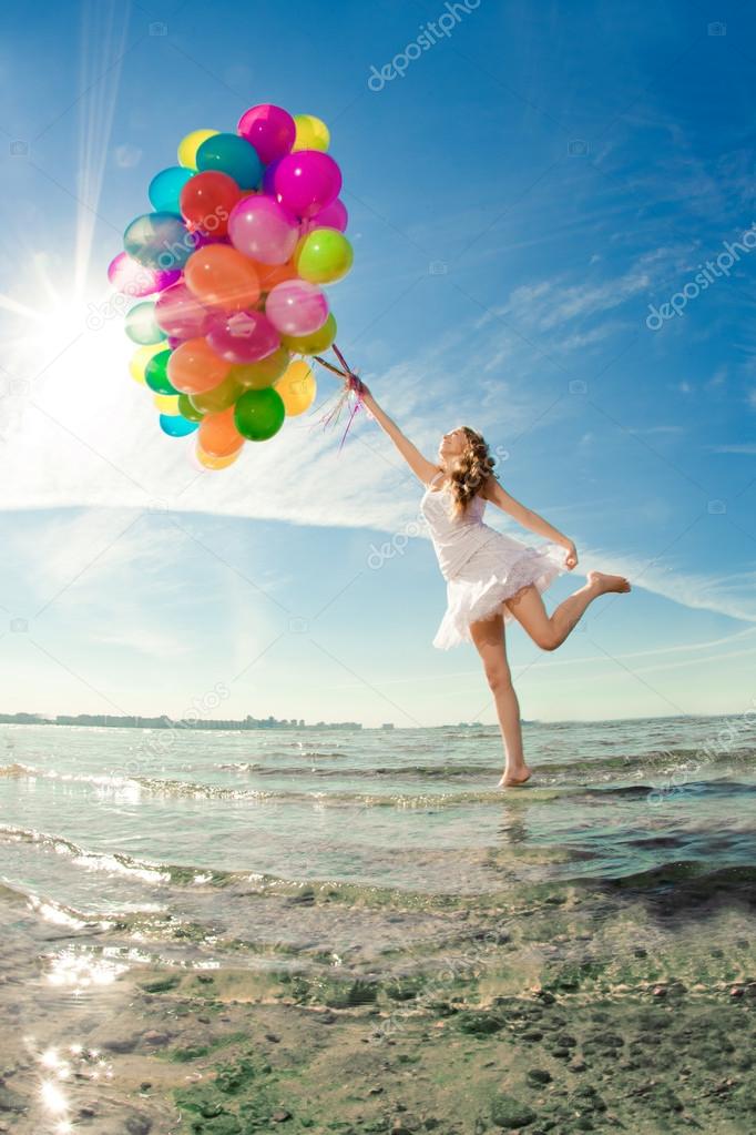 Beautiful young stylish woman with multi-colored rainbow balloon