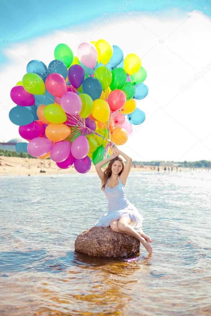 Beauty young stylish woman with multi-colored rainbow balloons i