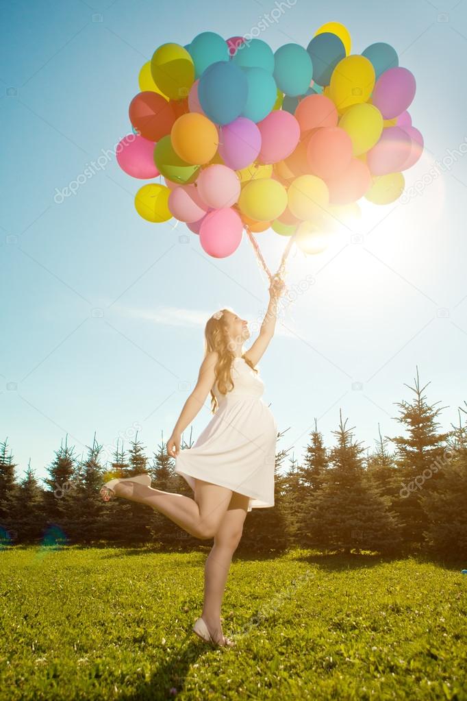Young healthy beauty pregnant woman with balloons outdoors. A g