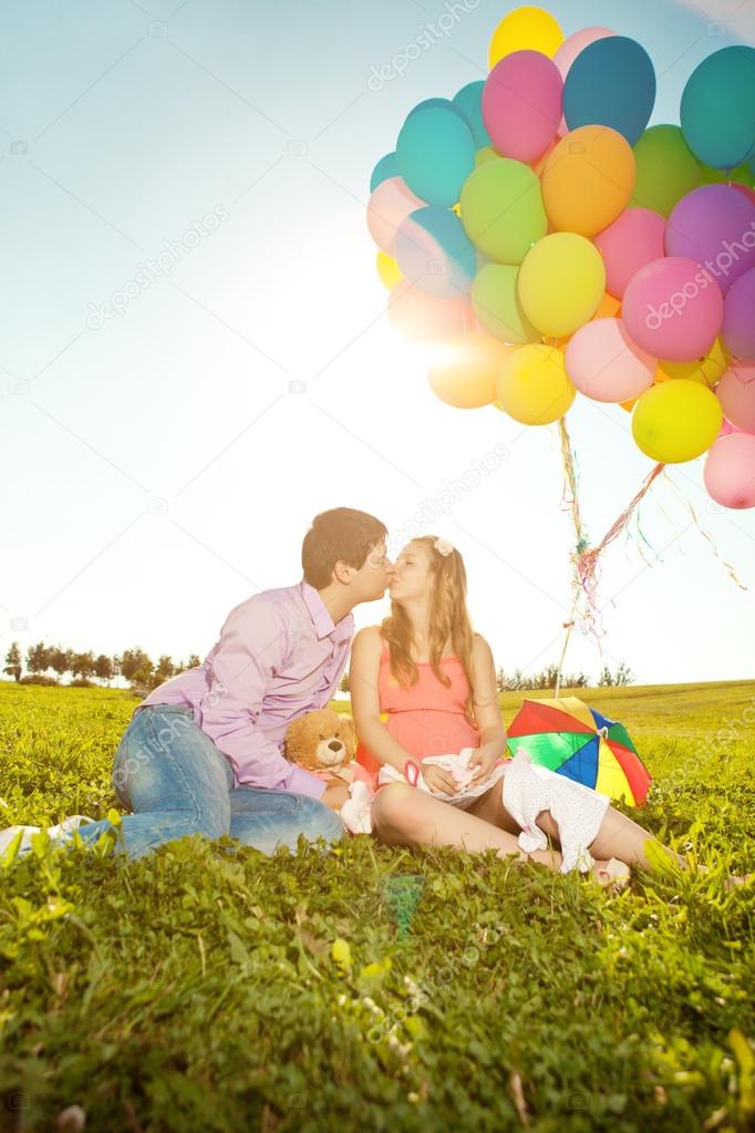 Young healthy beauty pregnant woman with her husband and balloon