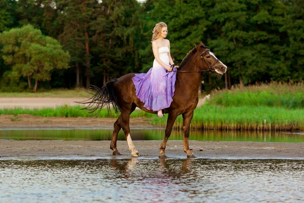 Two riders on horseback at sunset on the beach. Lovers ride hors — Stock Photo, Image