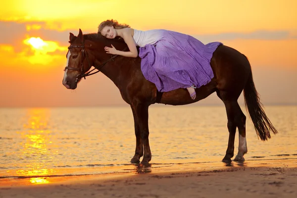 美丽的女人，在日落时分在海滩上骑马。年轻的 bea — 图库照片