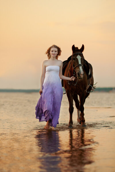 Красивая женщина верхом на лошади на закате на пляже. Young gir

