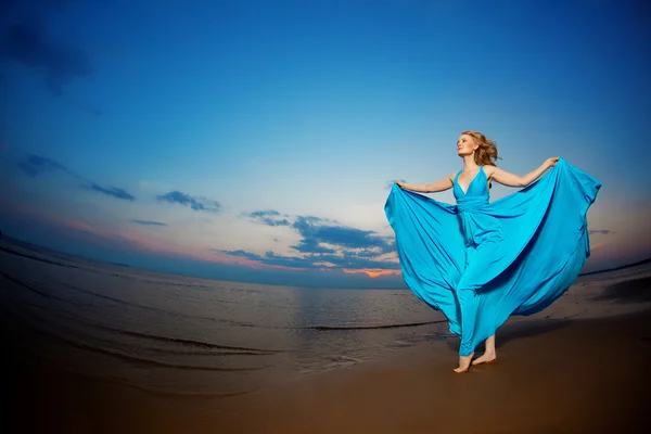 Donna di lusso in un lungo abito da sera blu sulla spiaggia. Bellezza — Foto Stock