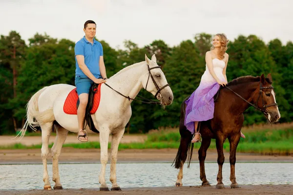 Mann und Frau mit einem Pferd am Meer. Romantische Liebe. Stockfoto