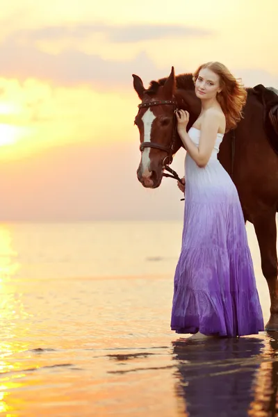 Mulher bonita montando um cavalo ao pôr do sol na praia. Jovem gir Fotos De Bancos De Imagens Sem Royalties