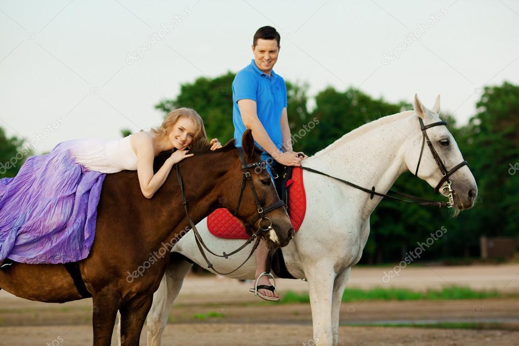 Two riders on horseback at sunset on the beach. Lovers ride hors