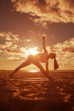 genç güzel ince kadın silueti beac yoga uygulamaları