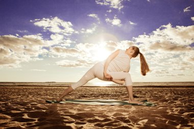 genç güzel ince kadın uygulamaları yoga gün batımında sahilde