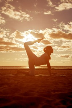 genç güzel ince kadın silueti beac yoga uygulamaları