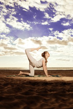 genç güzel ince kadın uygulamaları yoga gün batımında sahilde