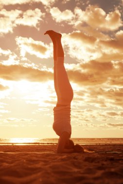 genç güzel ince kadın silueti beac yoga uygulamaları