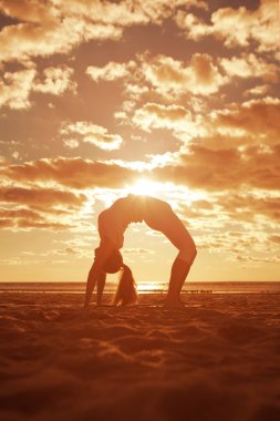 genç güzel ince kadın silueti beac yoga uygulamaları
